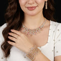 طقم كبير بأسلوب العقد المنسدل العريض مرصع بالأحجار الأبيض والكيوبِك A large set featuring a wide, cascading necklace style, embellished with white stones and cubic zirconia.