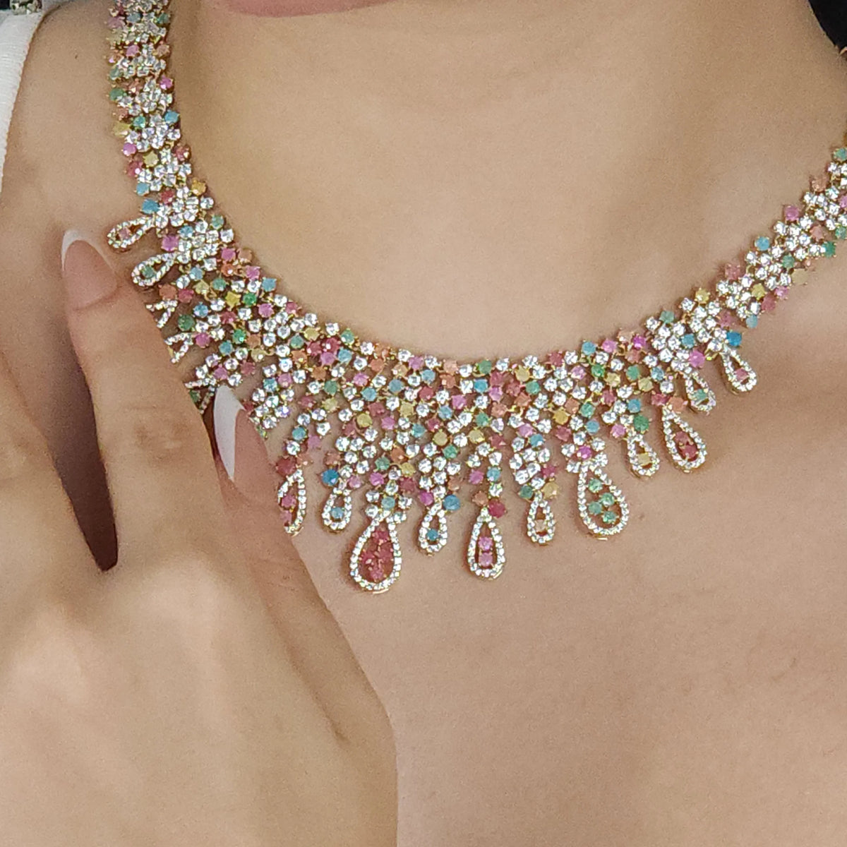 طقم كبير بأسلوب العقد المنسدل العريض مرصع بالأحجار الأبيض والكيوبِك A large set featuring a wide, cascading necklace style, embellished with white stones and cubic zirconia.
