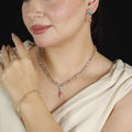 طقم مجوهرات باحجار الكيوبك الملونة بأسلوب الباستيل المتدرج Jewelry set featuring colored cubic zirconia stones in a gradient pastel style.